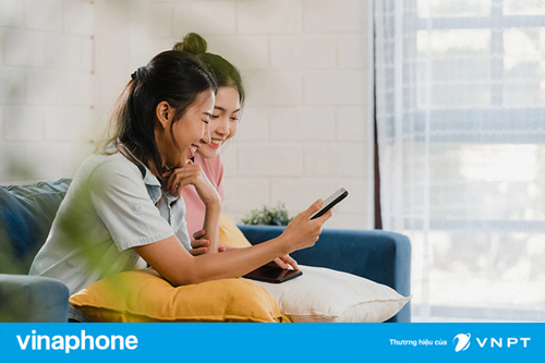 2 cô gái ngồi xem điện thoại